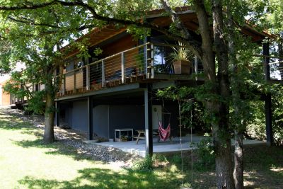 Vue extérieure d'une maison dans la pente sur pilotis conçue par Luis Acedo